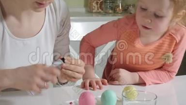 母亲和女儿用彩色<strong>颜料画</strong>复活节彩蛋